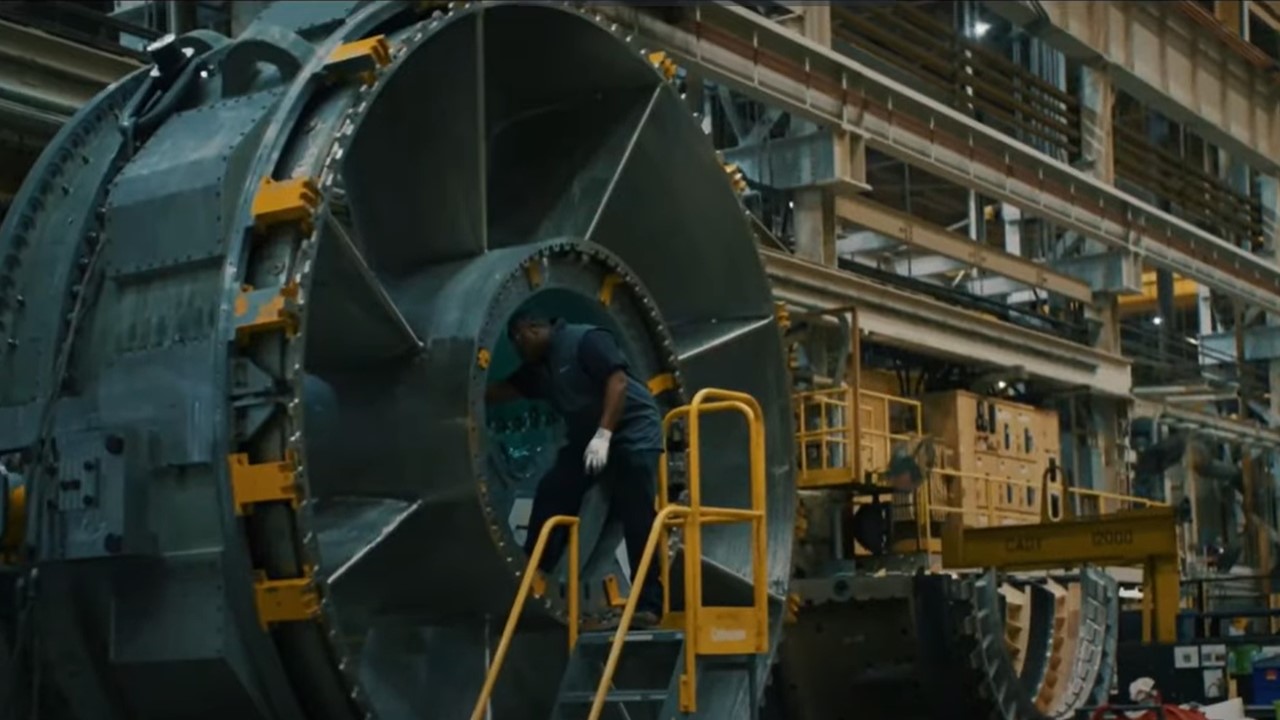 A man operates a turbine in the factory