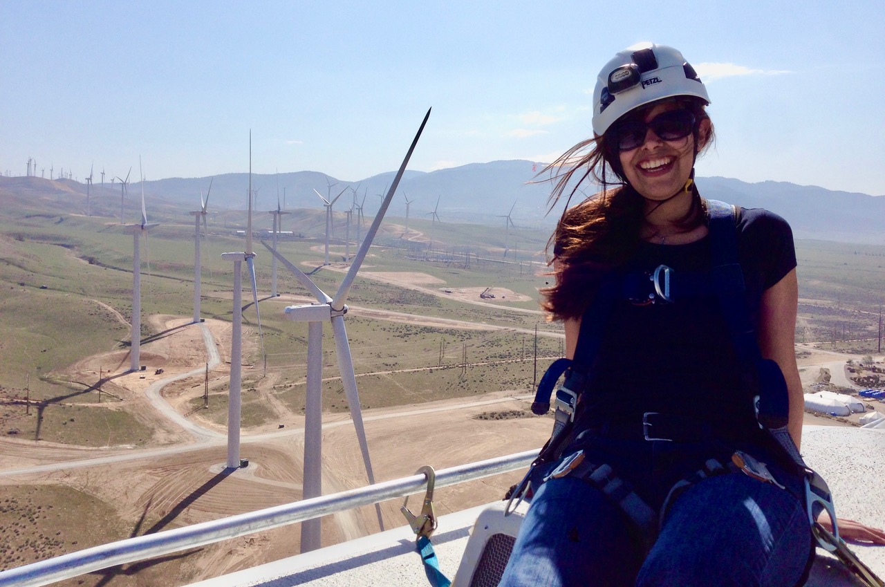 Woman poses at the top of a wind turbine
